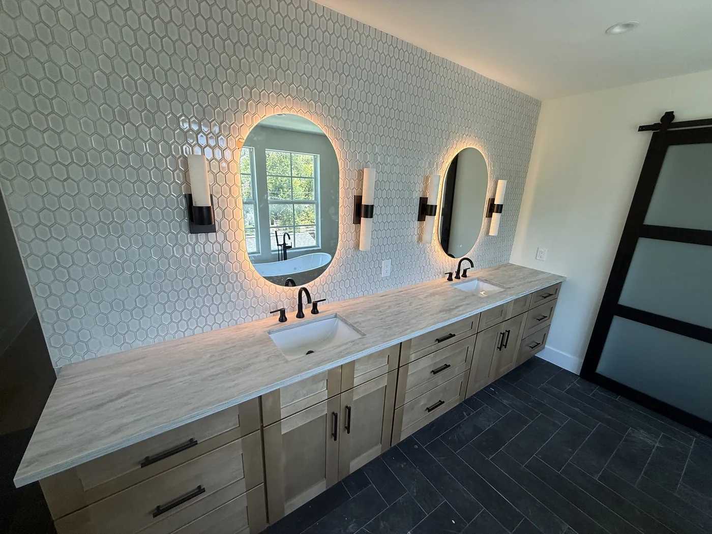 Double vanity with hex tile backsplash and backlit mirrors