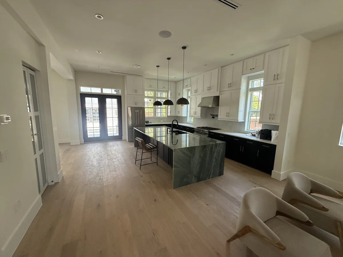 Open plan kitchen with an island, custom cabinetry and wide-plank wood flooring